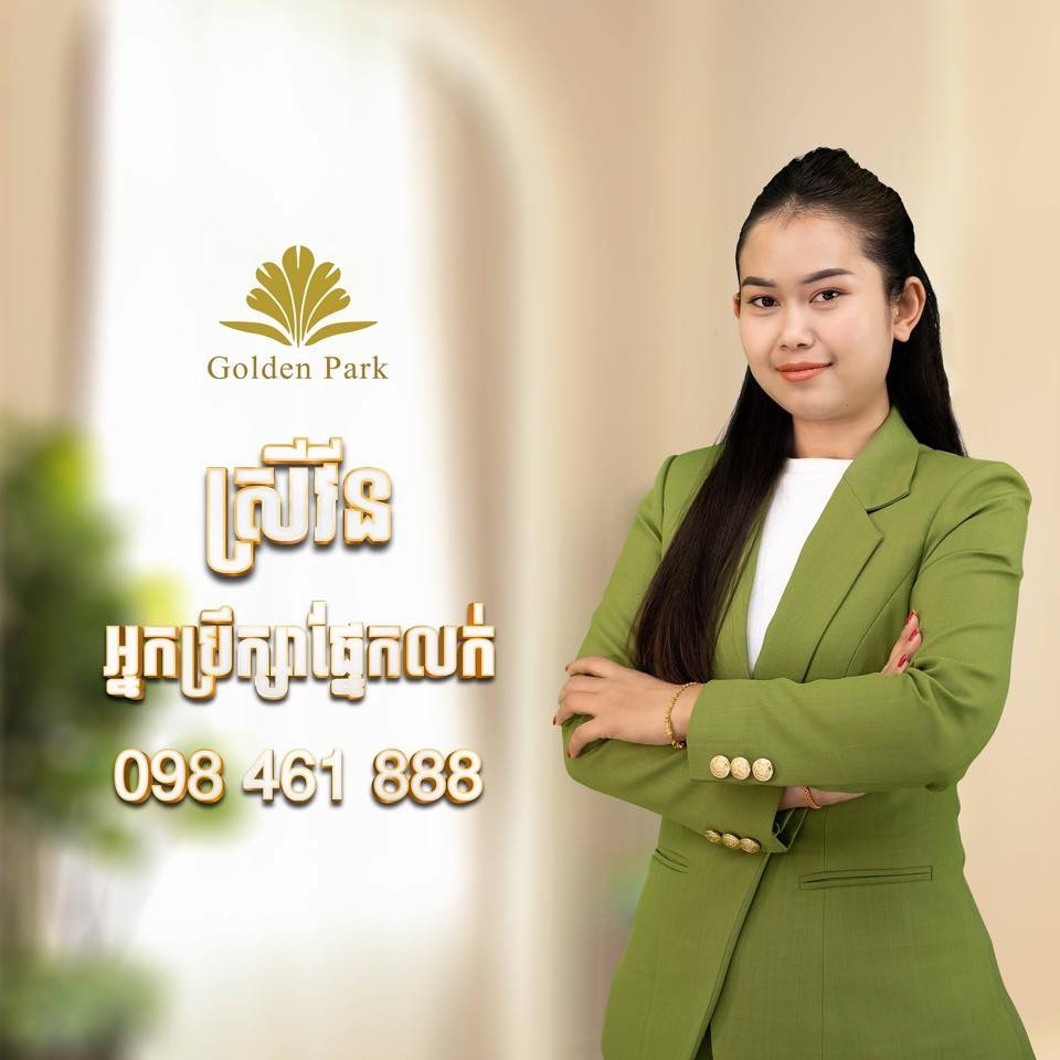 Woman in a green suit standing against a blurred background with 'Golden Park' branding.