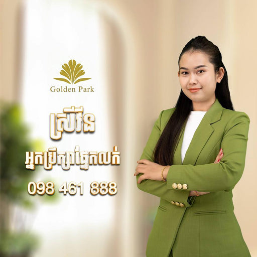 Woman in a green suit standing against a blurred background with 'Golden Park' branding.