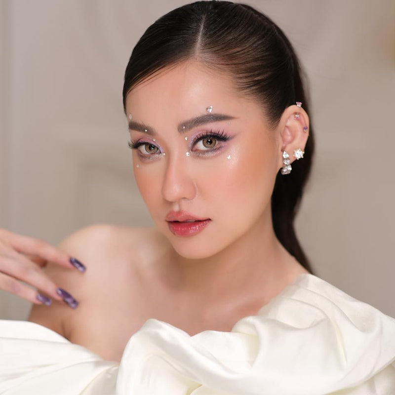 Woman with elegant makeup and jewelry against a neutral background