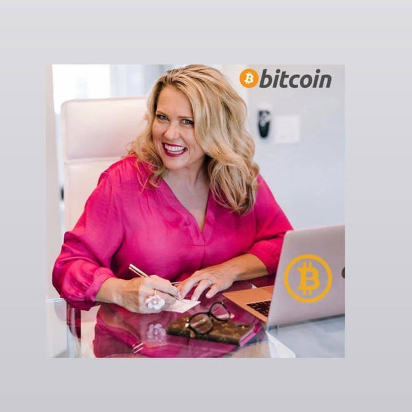 Woman in pink shirt sitting at a desk with a laptop and Bitcoin logo, on a light gray background.