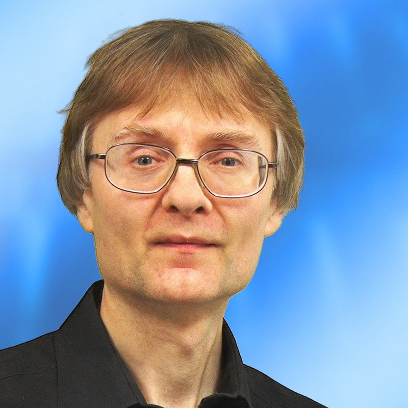 Person with glasses and a black shirt against a blue background