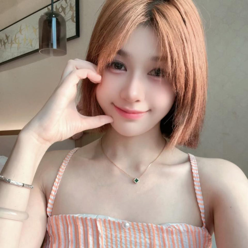 Woman with short hair making a peace sign gesture indoors.