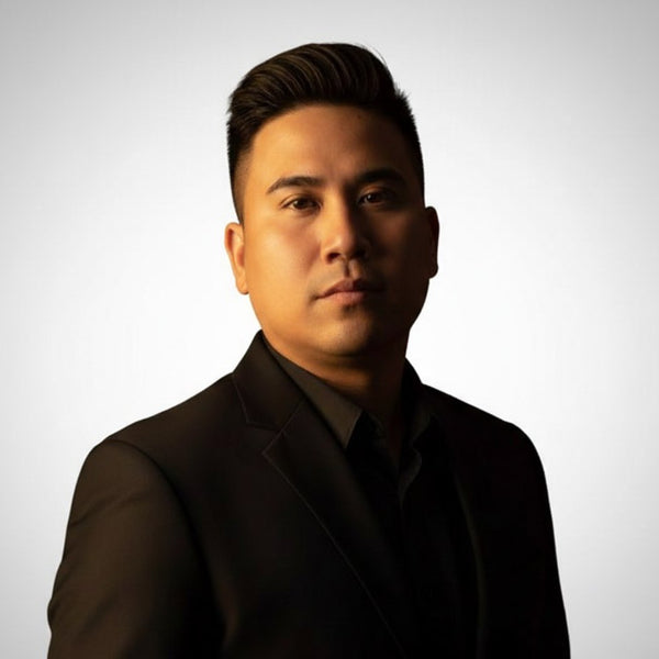 Man wearing a dark suit against a light background
