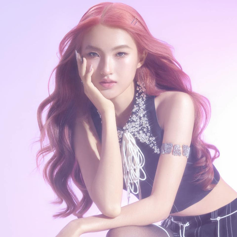 Woman with pink hair posing against a light purple background