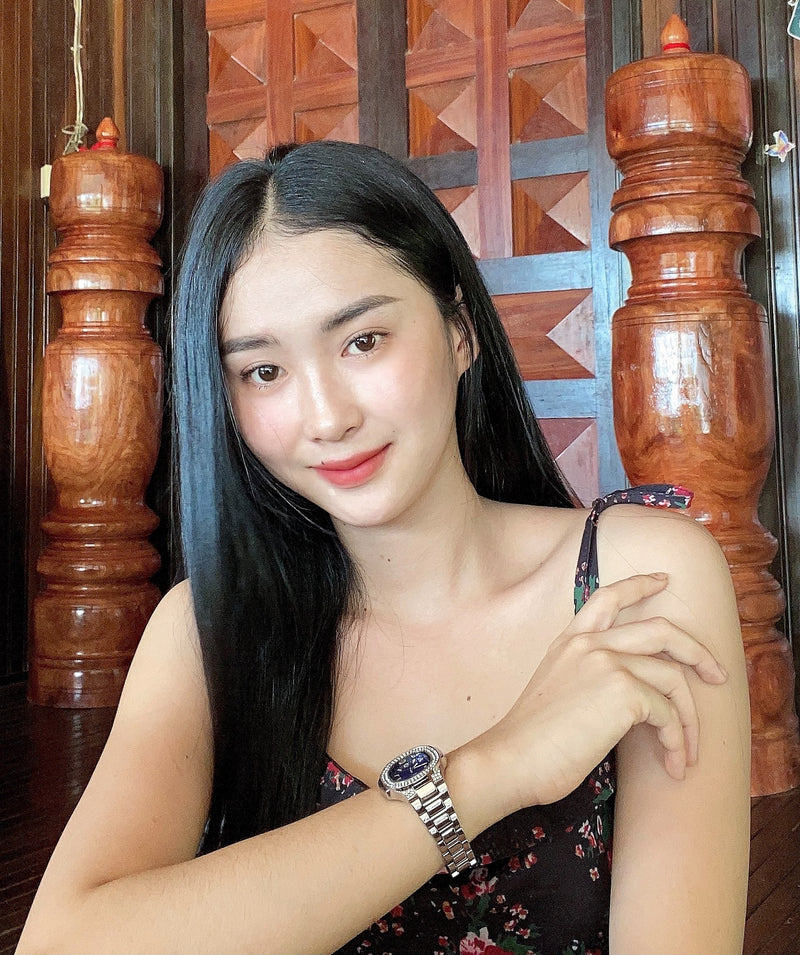 Woman wearing a watch with a wooden background