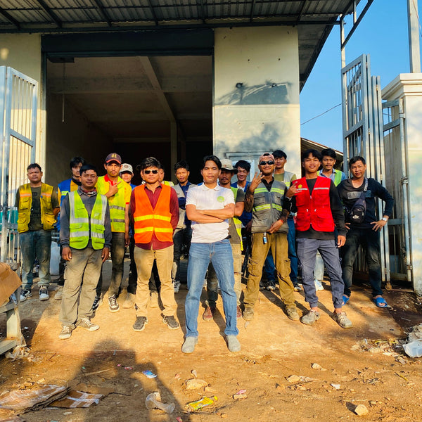 Group of people in safety vests standing in front of a building under construction.
