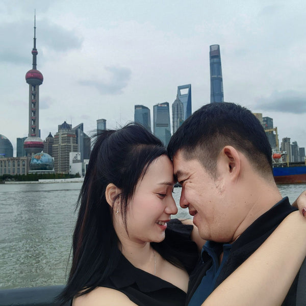 Two people embracing with a city skyline featuring modern skyscrapers in the background.