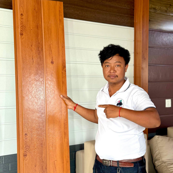 Person pointing at a wooden door indoors
