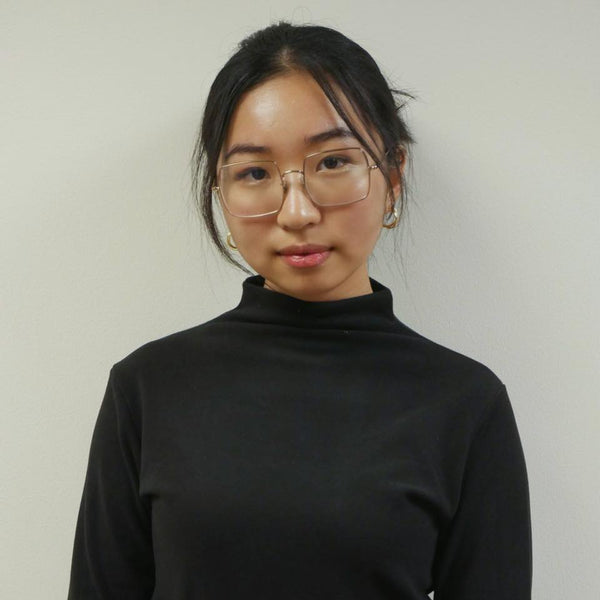 Person wearing a black turtleneck against a plain background