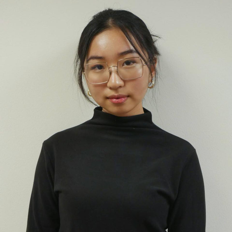 Person wearing a black turtleneck against a plain background