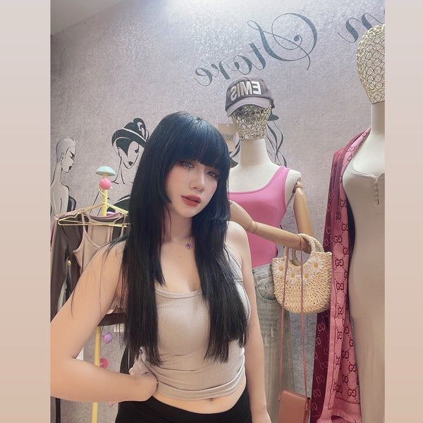 Woman posing in a clothing store with mannequins and fashion items in the background