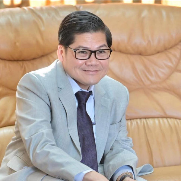 Man in a suit sitting on a beige couch