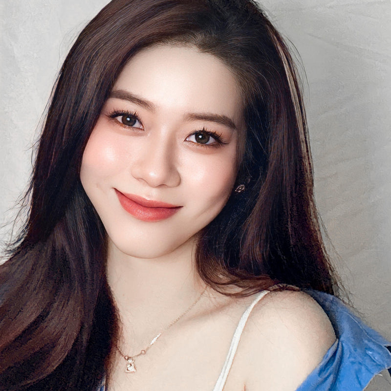 Woman with long dark hair and red lipstick against a neutral background