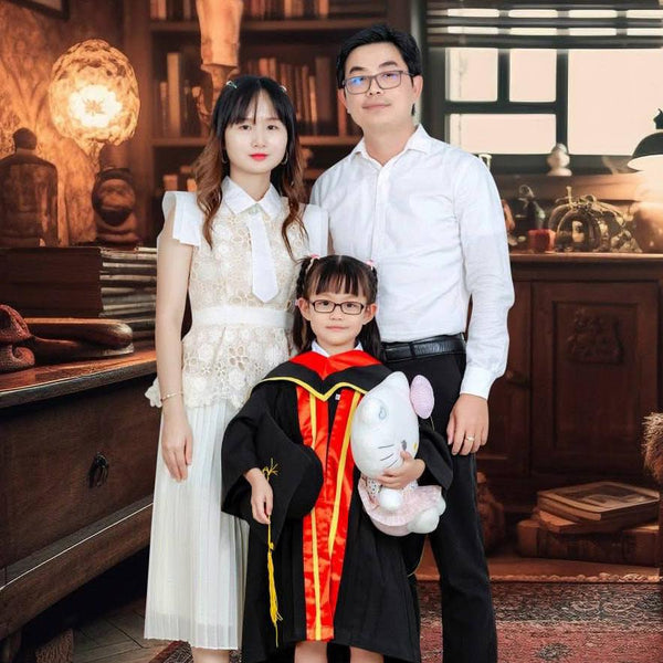 Family of four posing together in a decorated room with wooden furniture and decorative items.