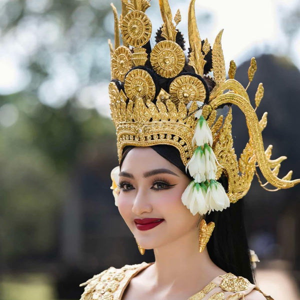 Woman wearing a traditional gold and black headdress with floral decorations.