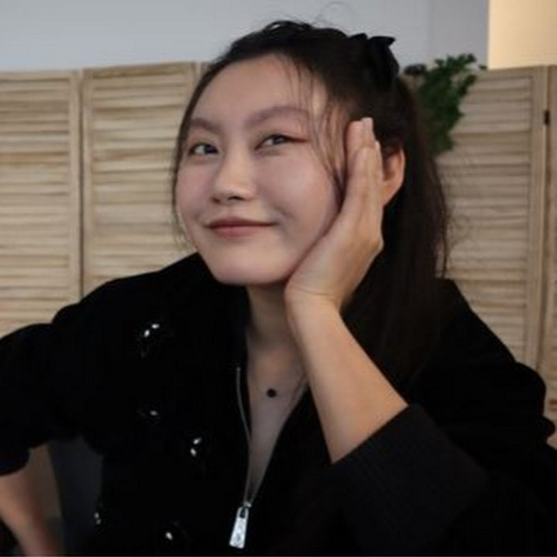 Person wearing a black outfit with a textured background